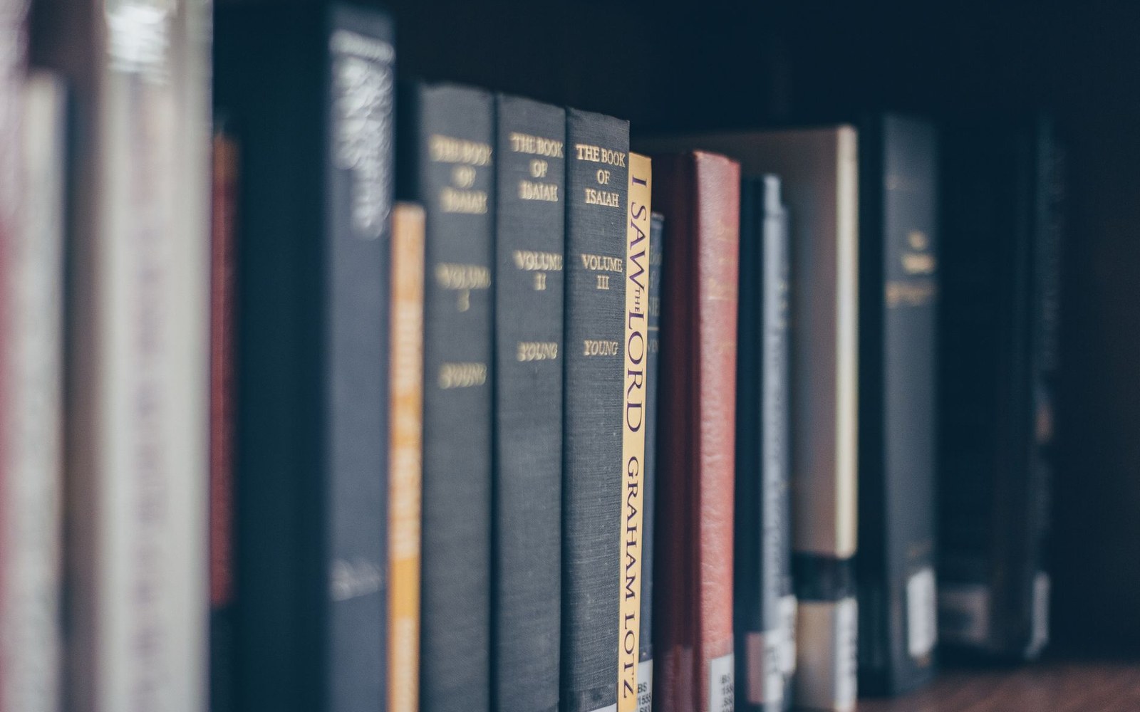 Row of hardcover book spines including volumes of "The Book of Isaiah" and "I Saw the Lord"